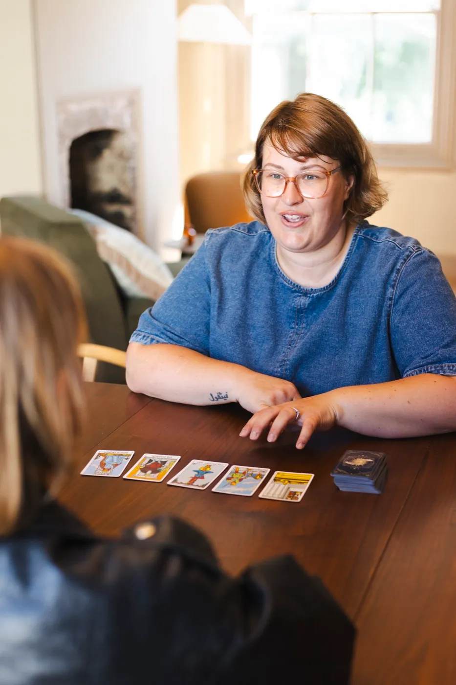Gemma Hurlstone laying out tarot cards at a table, mid-reading.